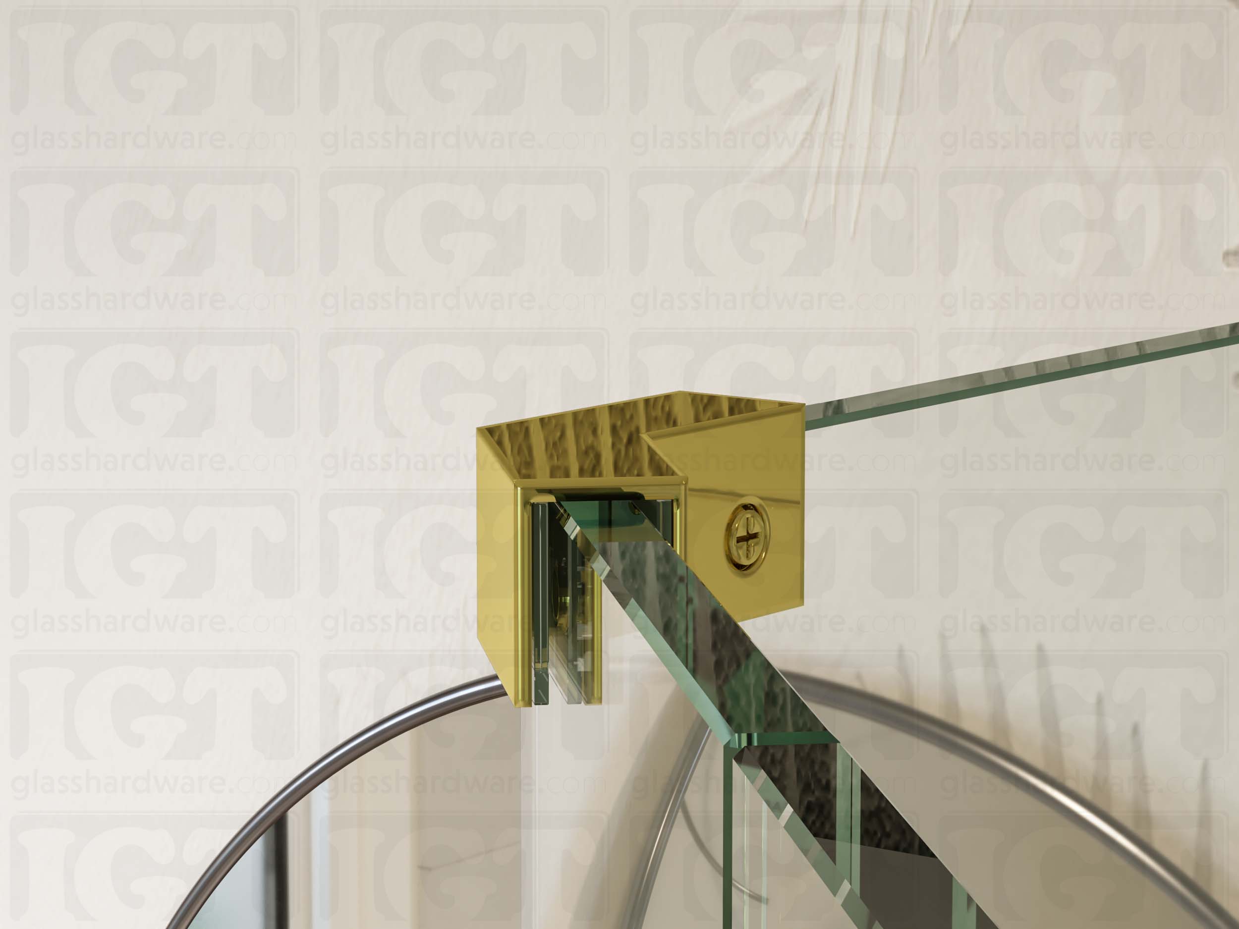 A close up view of the Glass-to-Glass 135 Degree Sleeve Over Clamp installed between two panels. A protective clear gasket rests between the clamp and glass panel. Polished Brass.