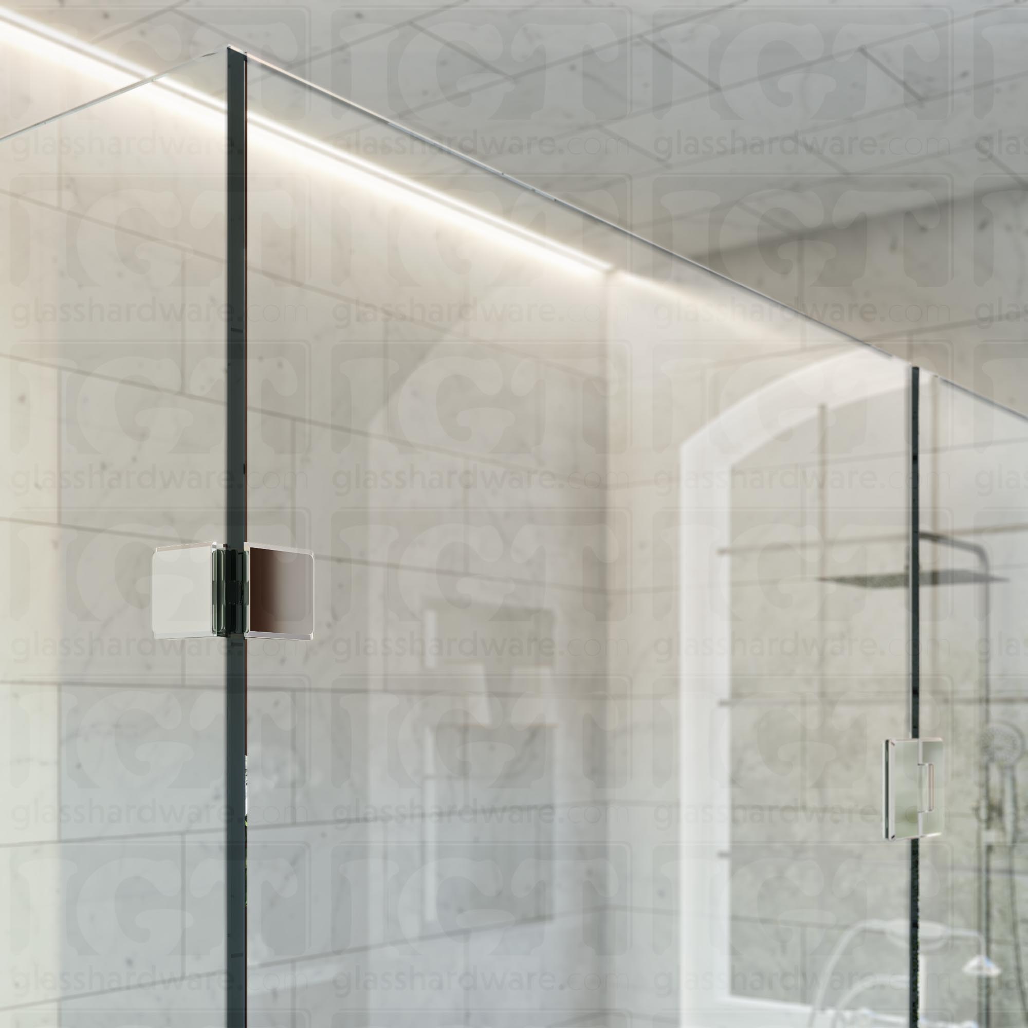 An upper view of the shower's glass panels, secured with a Glass-to-Glass 90 Degree Bilboa Clamp alongside a matching hinge. The hardware's corresponding finishes and beveled-edge design give the shower elegance and cohesiveness. Chrome Polished.
