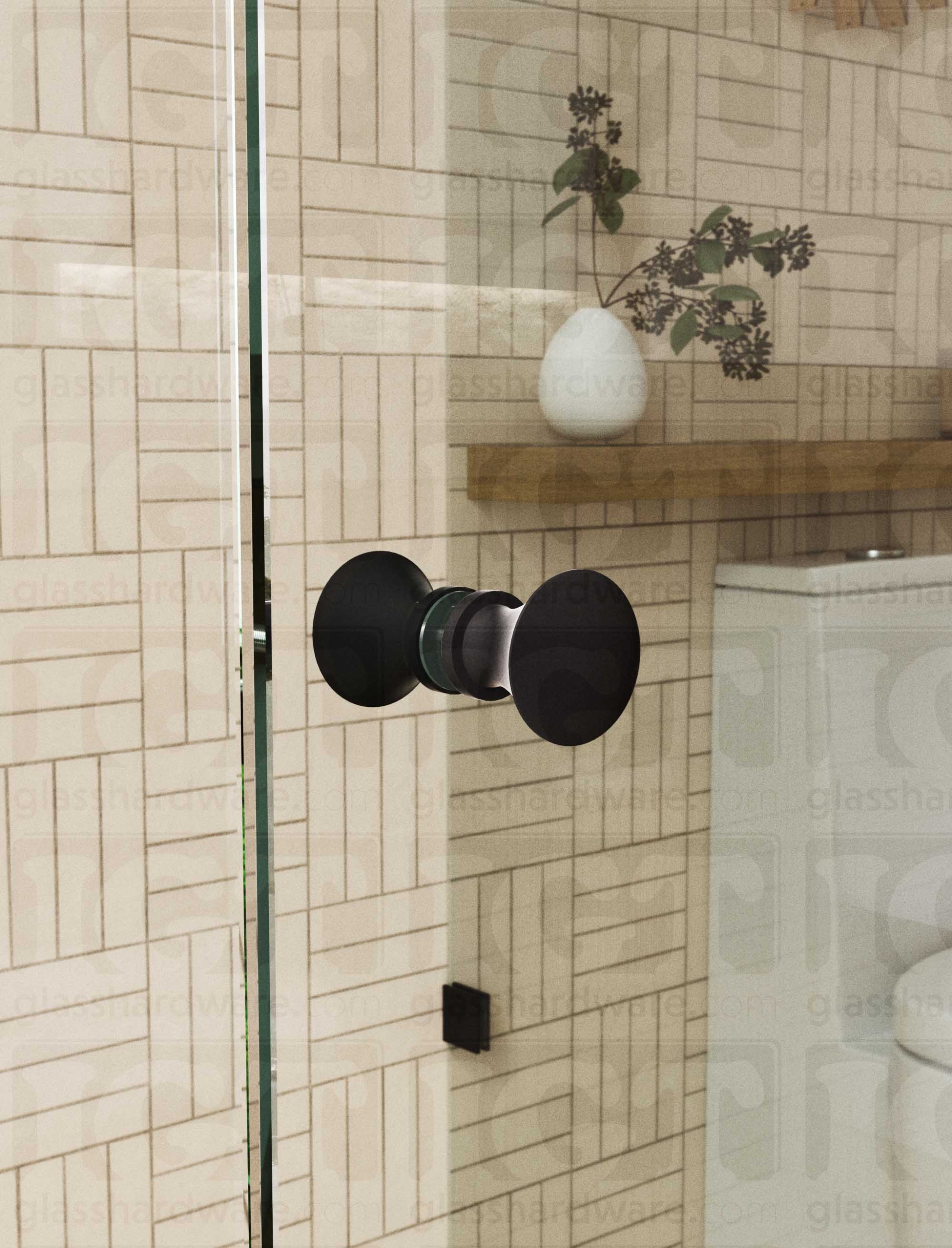 A close up of the Junior Traditional Back-to-Back Door Knob installed on a glass shower door. The door knob's back-to-back design is tightly secured to the glass door. Matte Black.