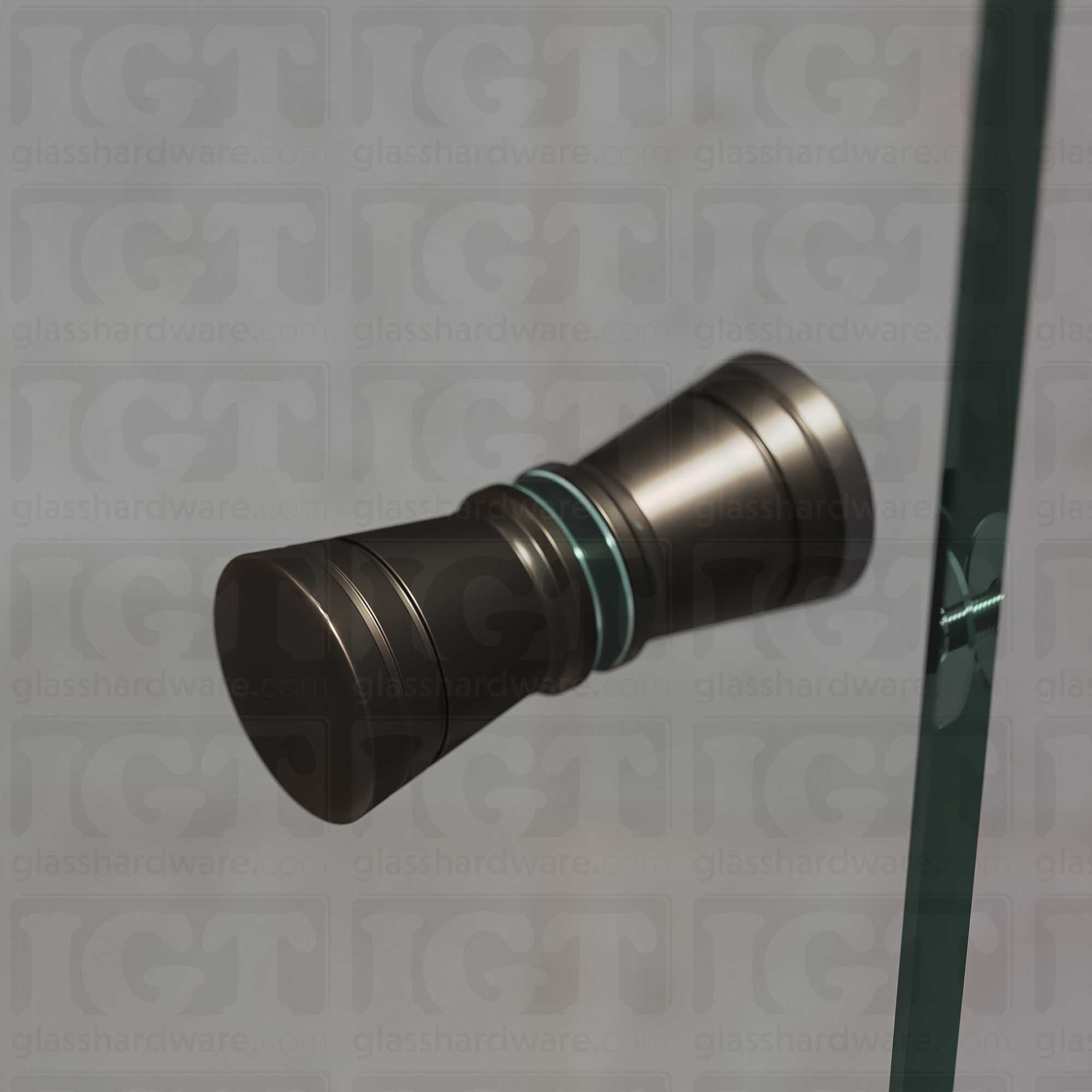 A close up of the Modern Ribbed Bow Tie Back-to-Back Door Knob installed on a glass shower door. Soft ambient light highlights the knob's Oil Rubbed Bronze finish.