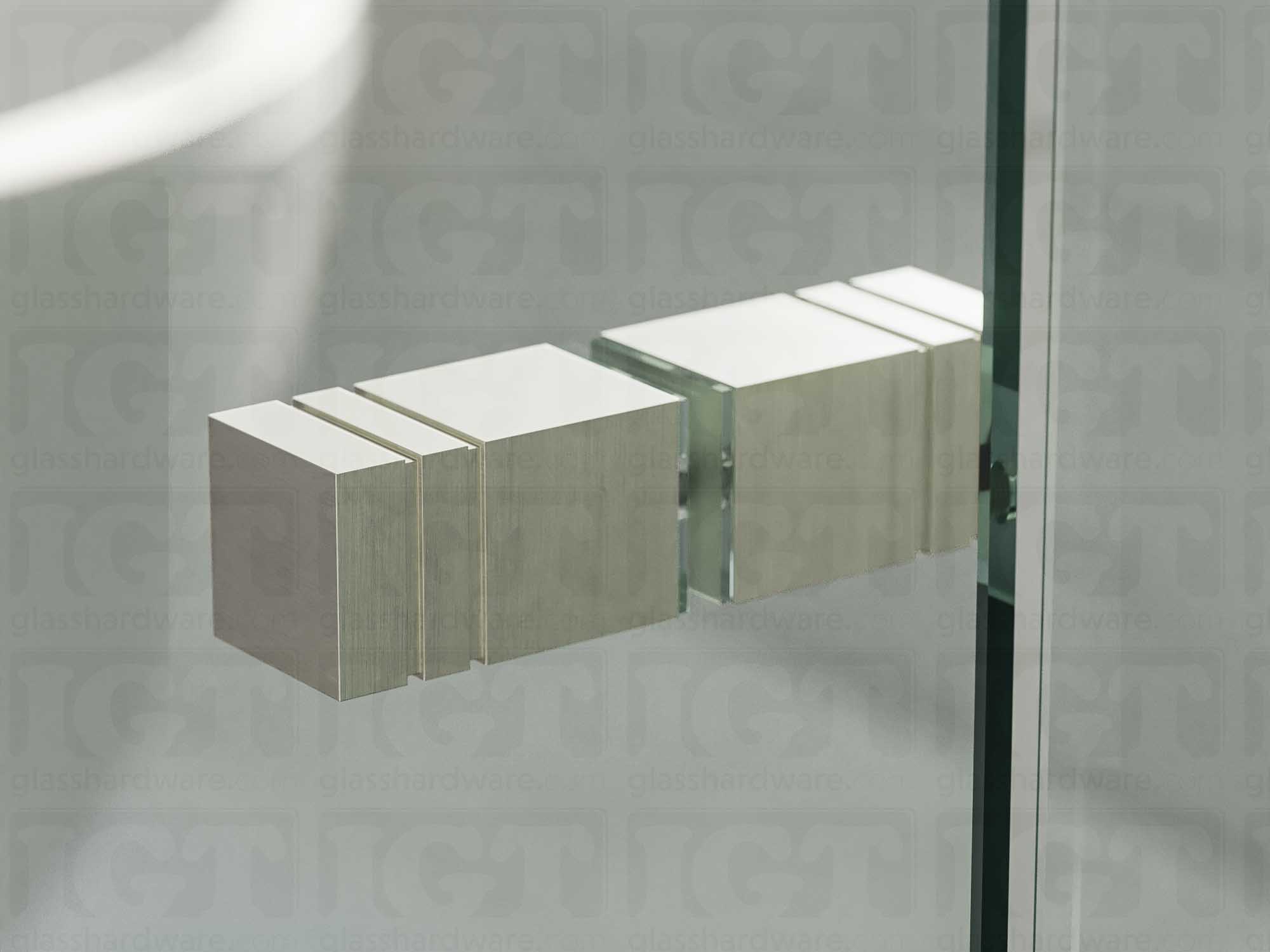 A close up of the Square Back-to-Back Door Knob installed on a glass shower door. Soft natural light highlights the knob's Brushed Nickel finish.