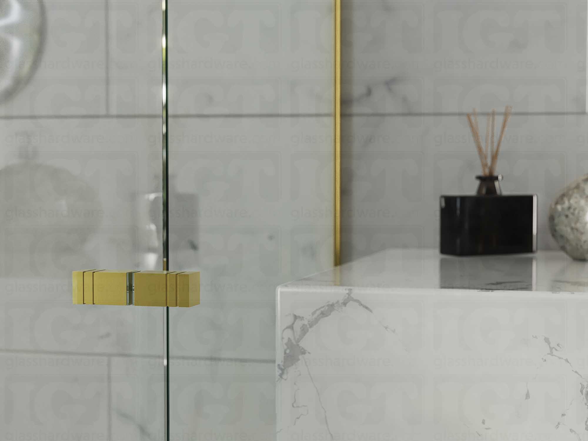 A close up of the Square Back-to-Back Door Knob installed on a glass shower door. Gold Brushed.