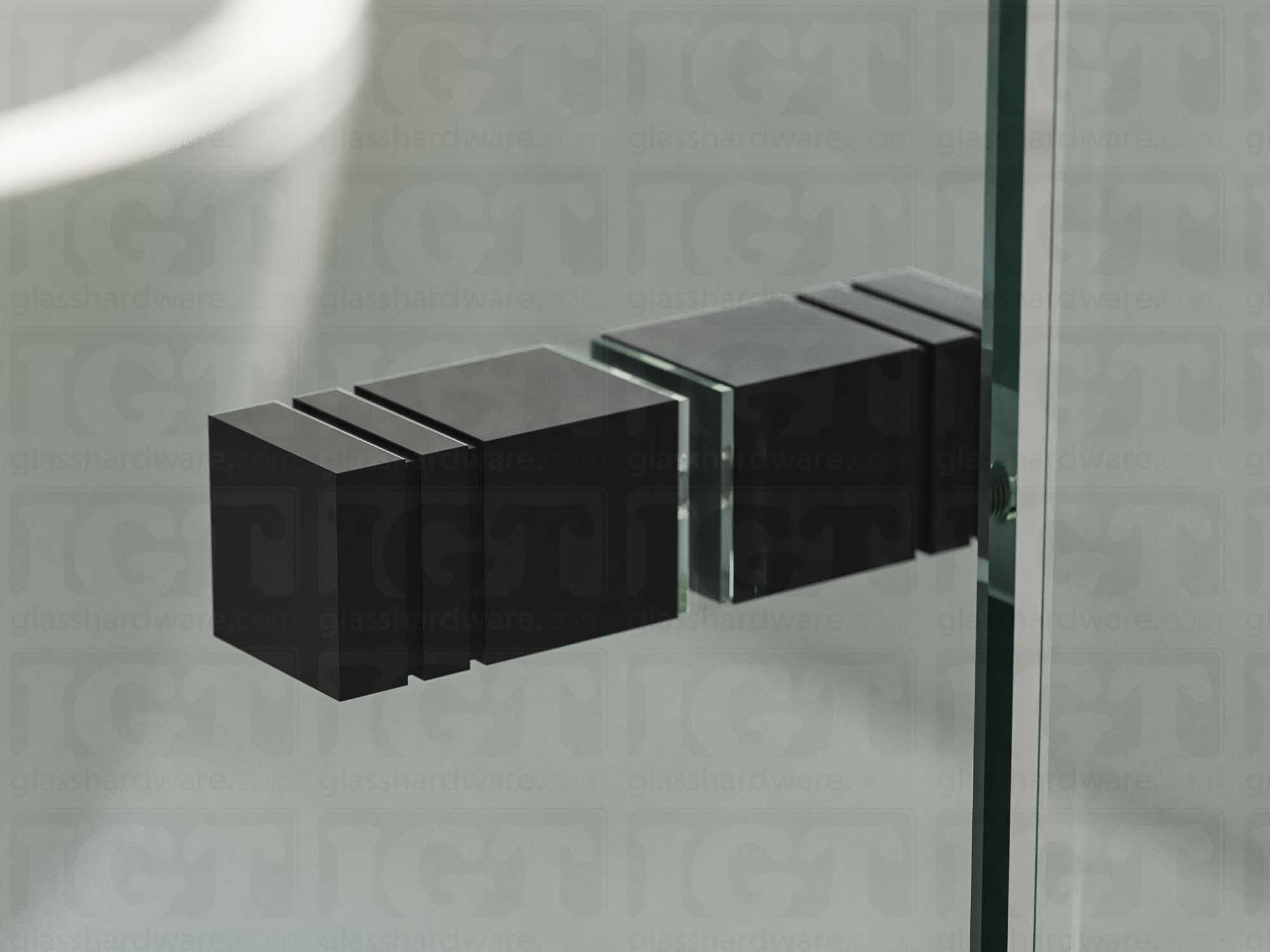 A close up of the Square Back-to-Back Door Knob installed on a glass shower door. Soft natural light highlights the knob's Matte Black finish.