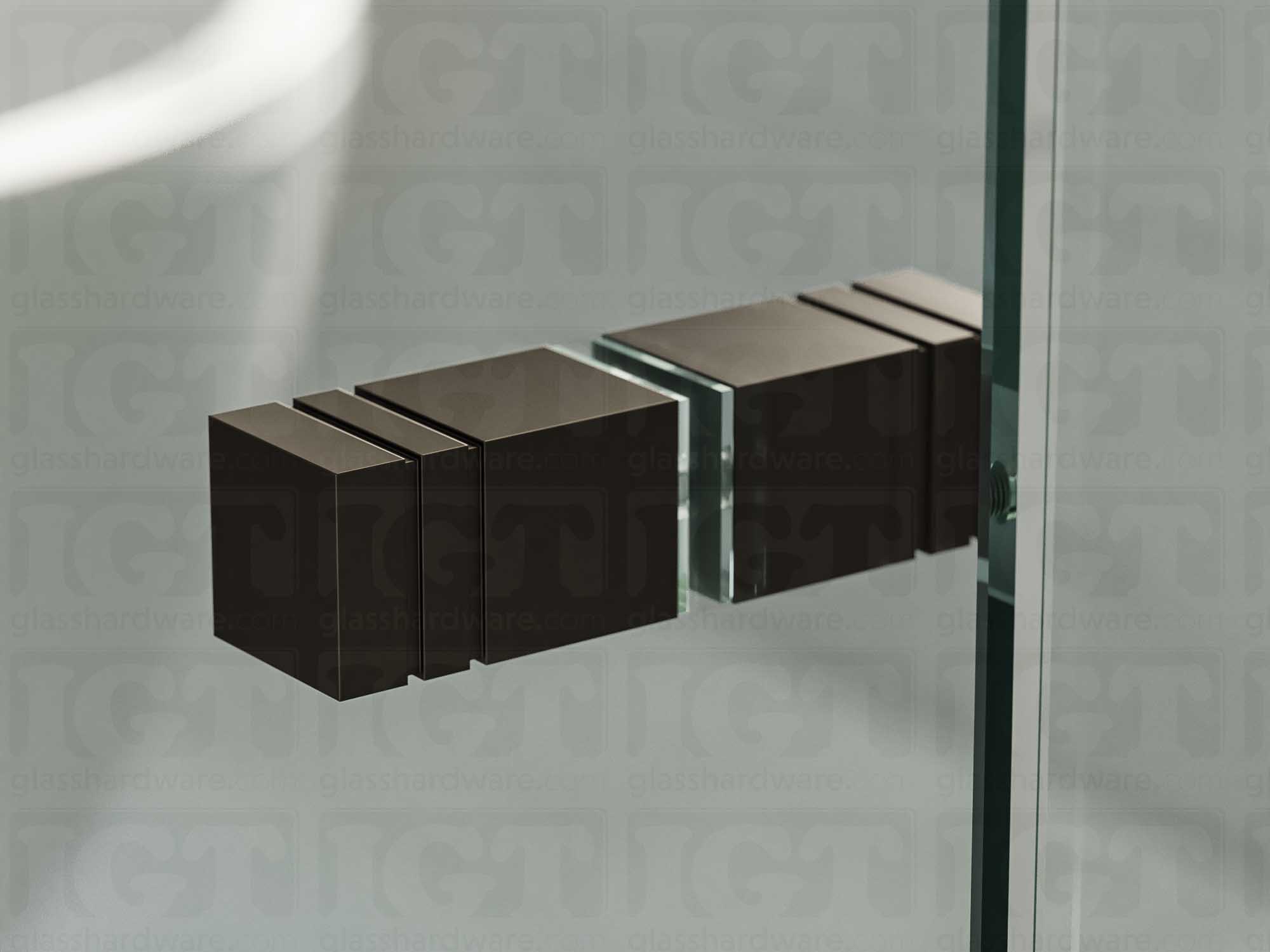 A close up of the Square Back-to-Back Door Knob installed on a glass shower door. Soft natural light highlights the knob's Oil Rubbed Bronze finish.
