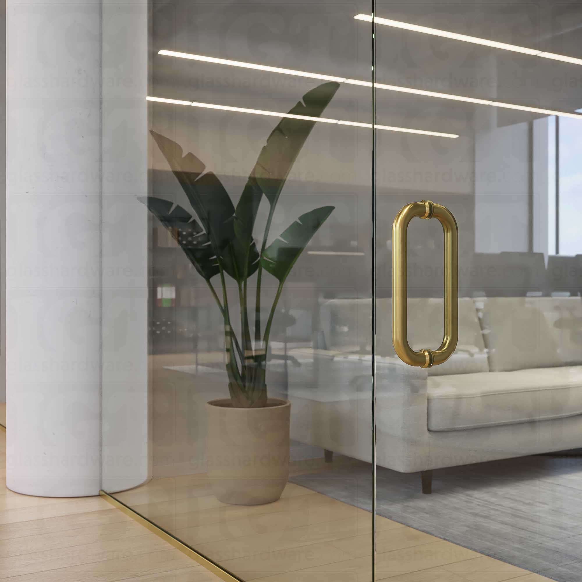 A close-up of the 12-inch Back-to-Back Round Pull Handle in Gold Brushed, installed on a commercial glass door.