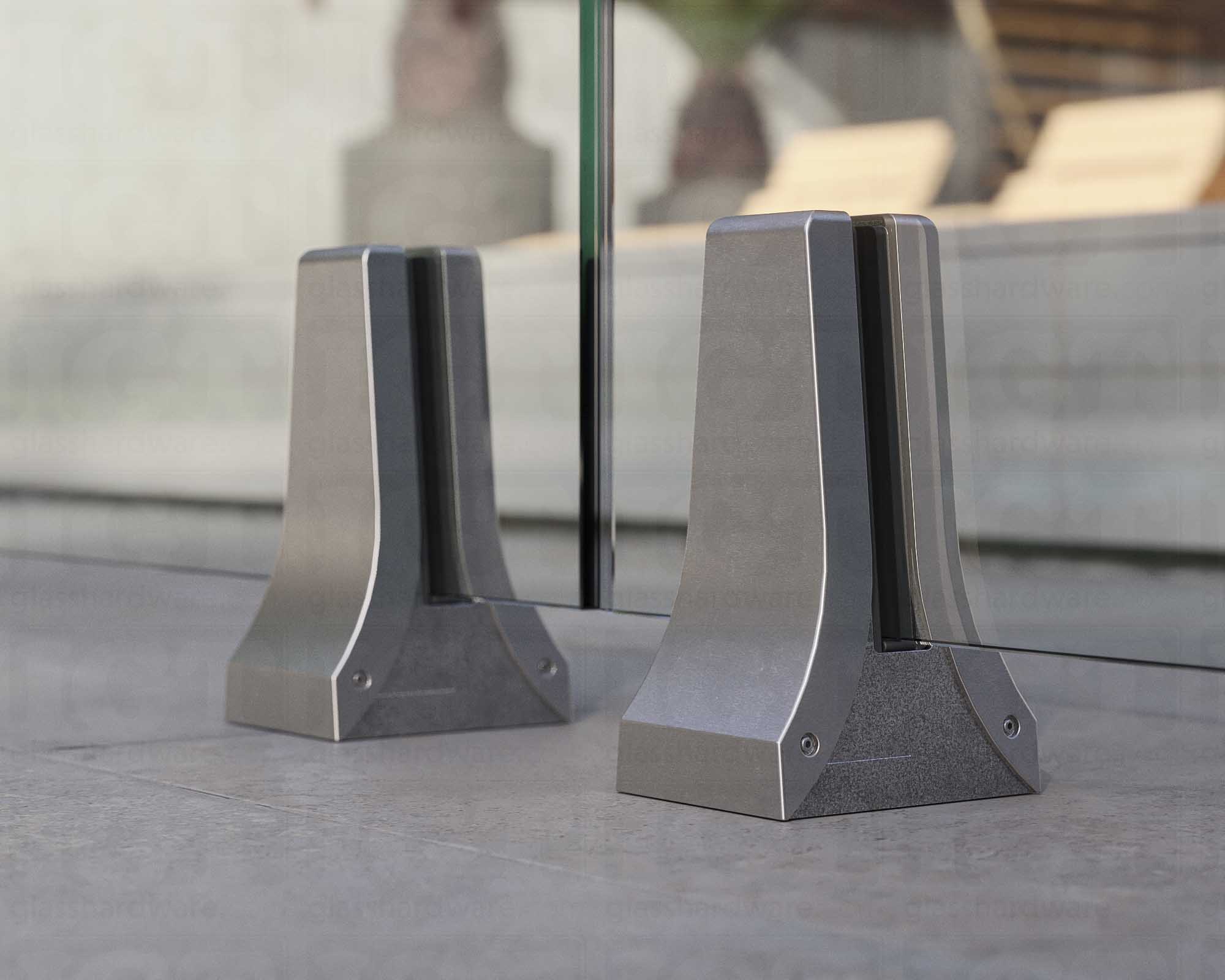 A close up of two 316L Stainless Steel Chameleon Spigots supporting a glass railing system. Brushed Stainless.