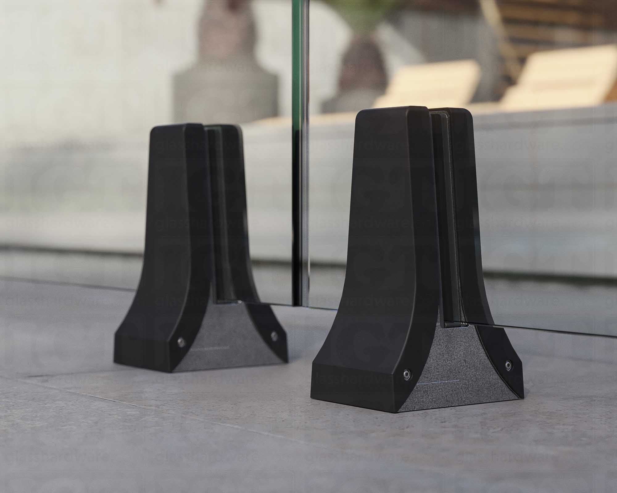 A close up of two 316L Stainless Steel Chameleon Spigots supporting a glass railing system. Matte Black.