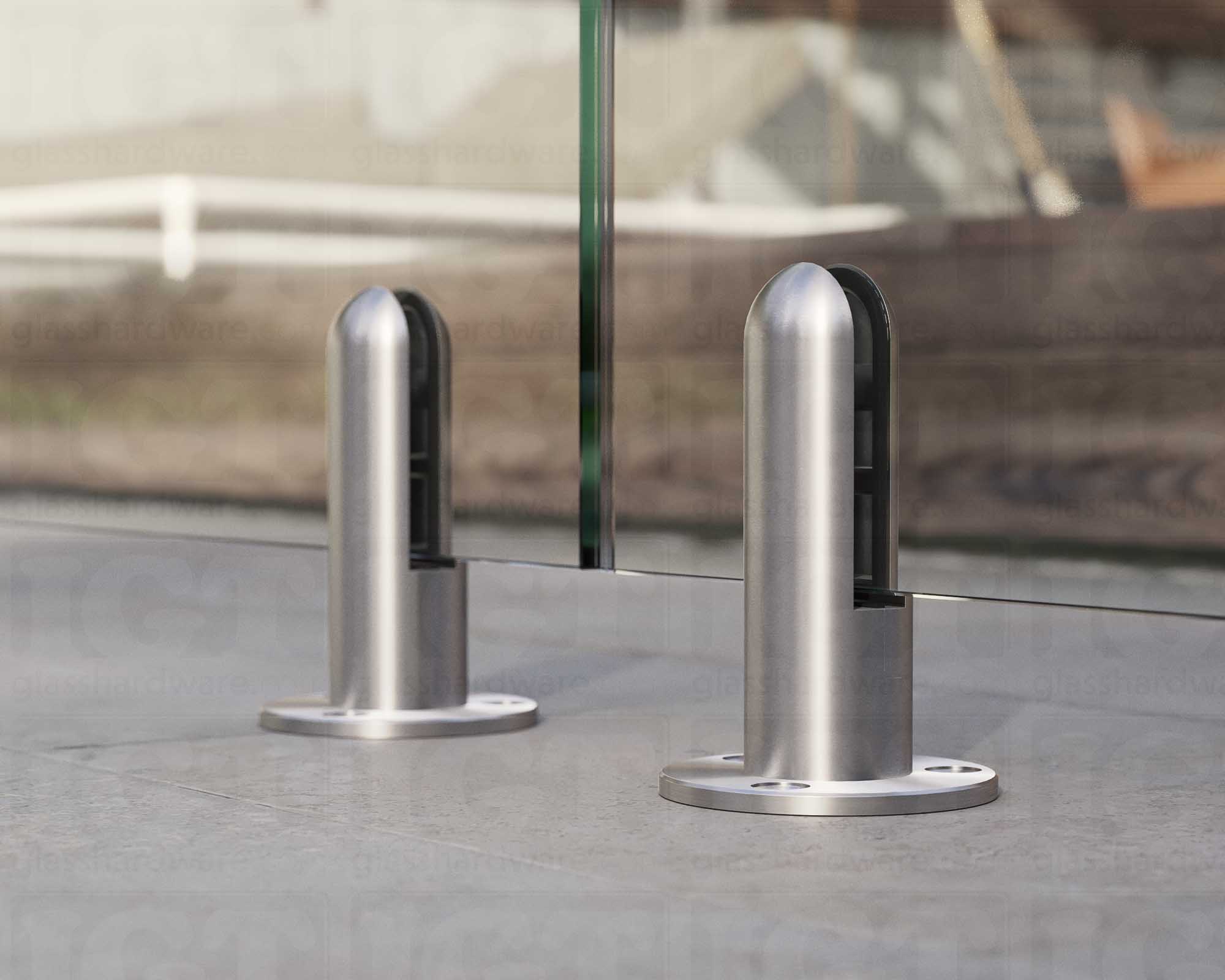 A close up of two 316L Stainless Steel Round Spigots supporting a glass railing system. Brushed Stainless.
