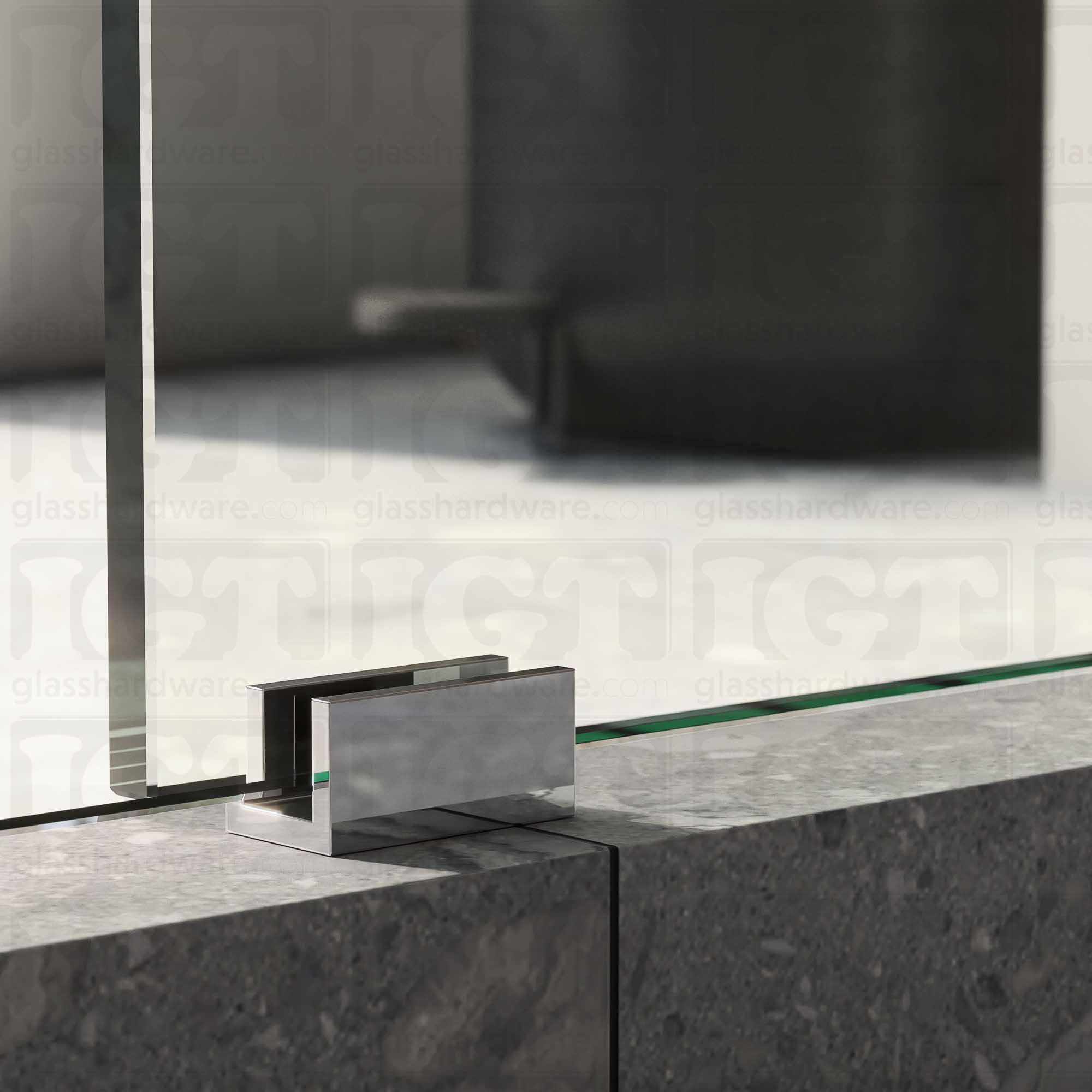 A close up of the Floor Guide for Modern Sliding System installed at the base of a glass sliding door, showcasing it's Chrome Polished finish.