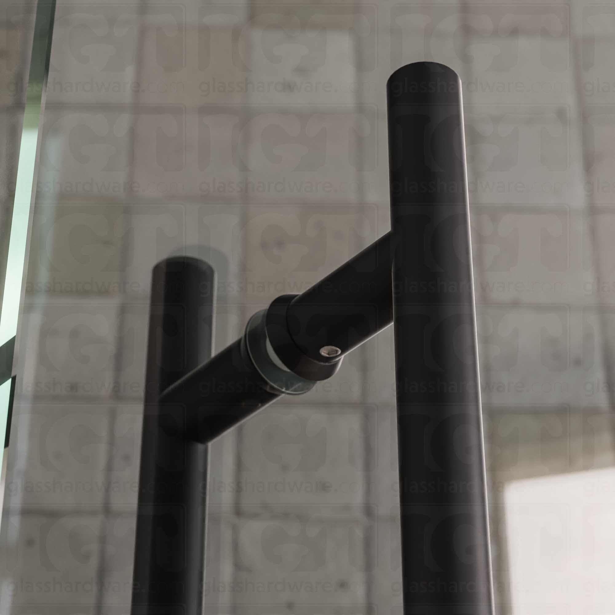 A close-up of the 6" Center-to-Center Round Ladder Handle installed on a glass shower door, showing its 304 Stainless Steel construction in more detail. Matte Black.
