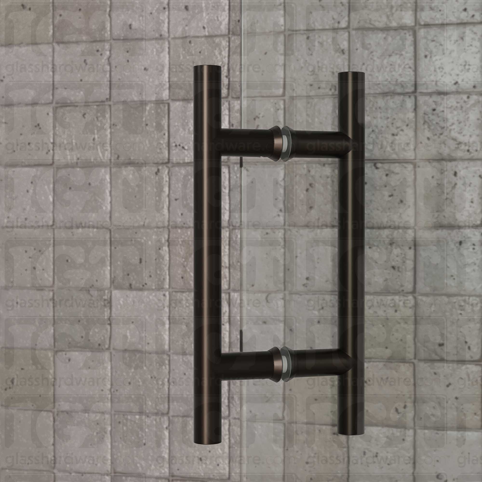 A close-up of the 6" Center-to-Center Round Ladder Handle installed on a glass shower door, showcasing its back-to-back design. Oil Rubbed Bronze.