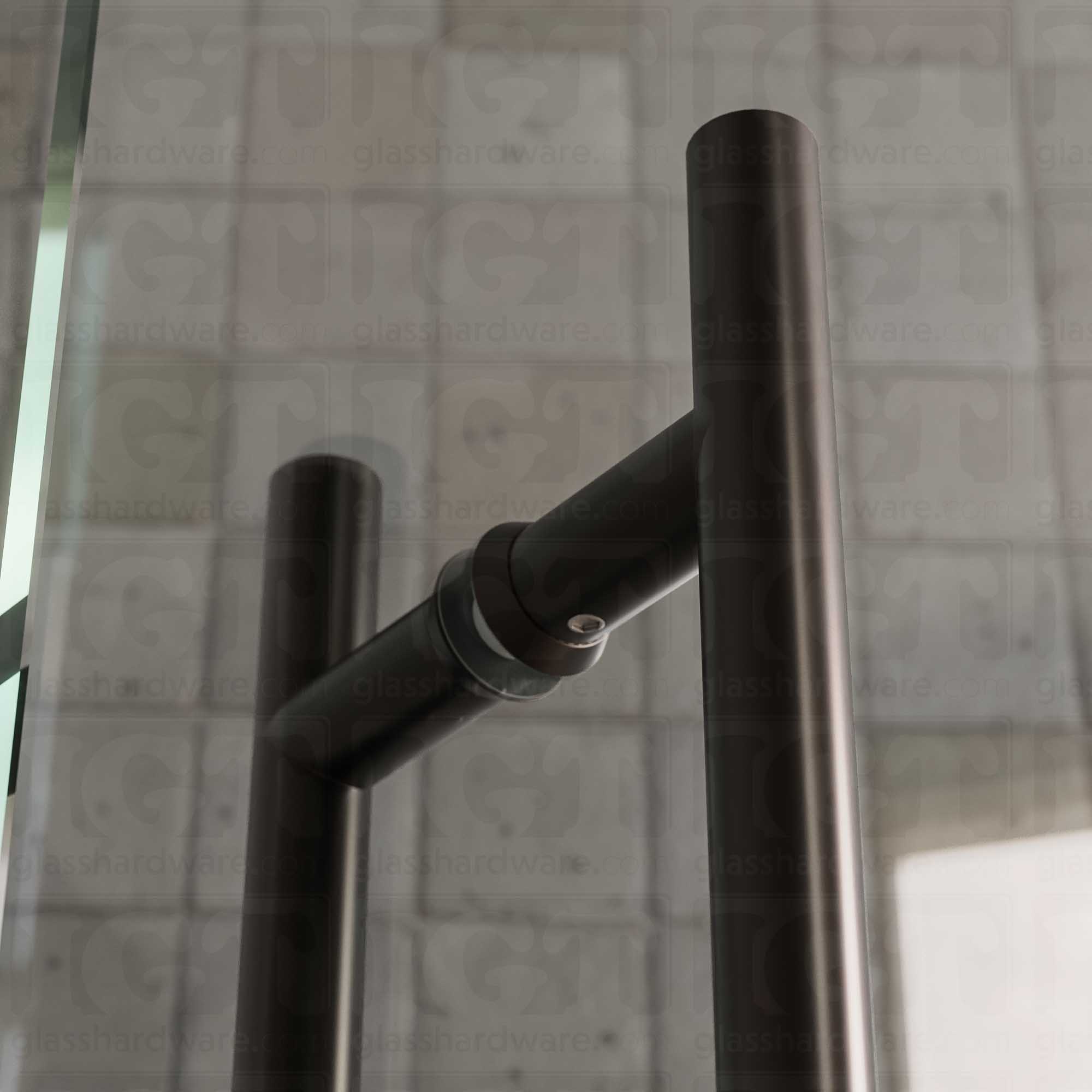 A close-up of the 6" Center-to-Center Round Ladder Handle installed on a glass shower door, showing its 304 Stainless Steel construction in more detail. Oil Rubbed Bronze.